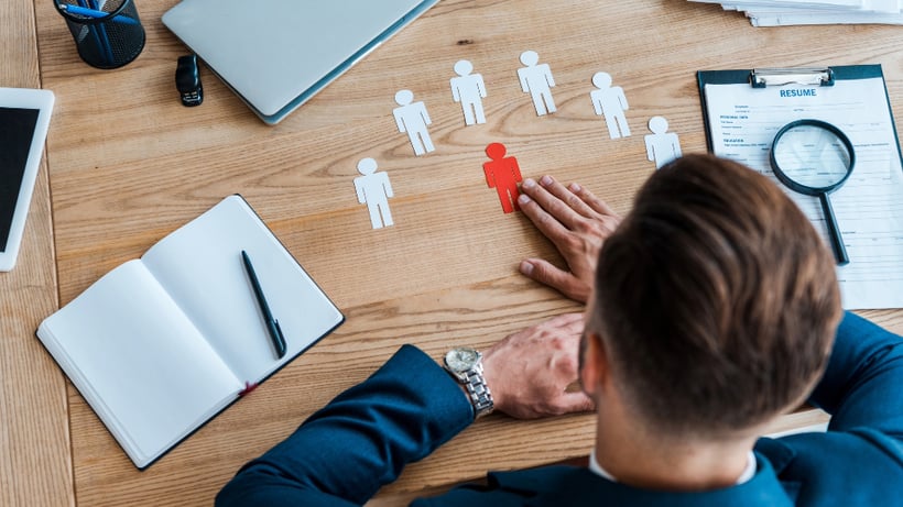 top view of man choosing paper shapes on a table