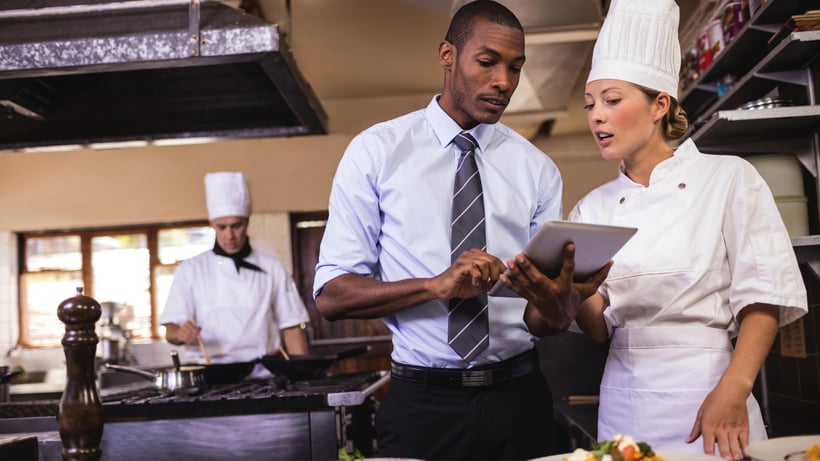 Food Safety Supervisor with ipad talking to a chef