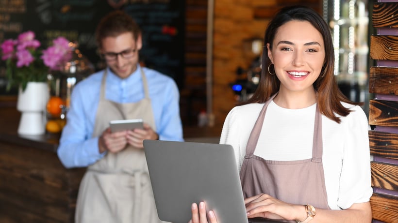 Food handlers with ipad and laptop in restaurant